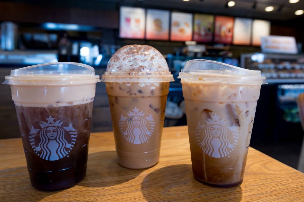 A batch of pumpkin spice lattes, iced pumpkin cream and fresh apple milk with oat shake on a table at Starbucks